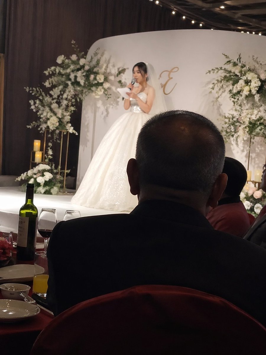 iPhone candid shot, the bride speaking on stage at a wedding, with…