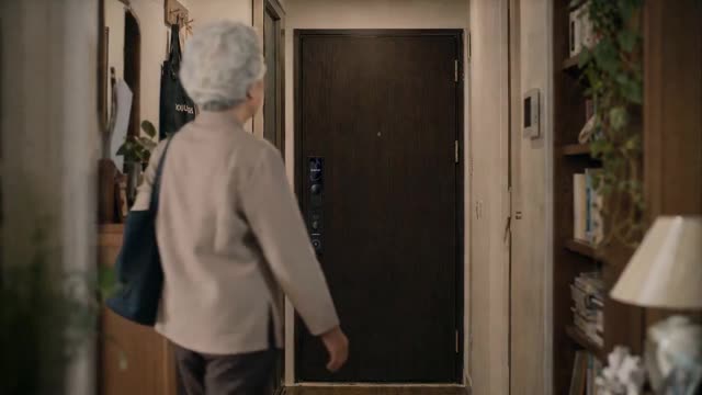 Elderly Woman Opens Apartment Door Smiling
